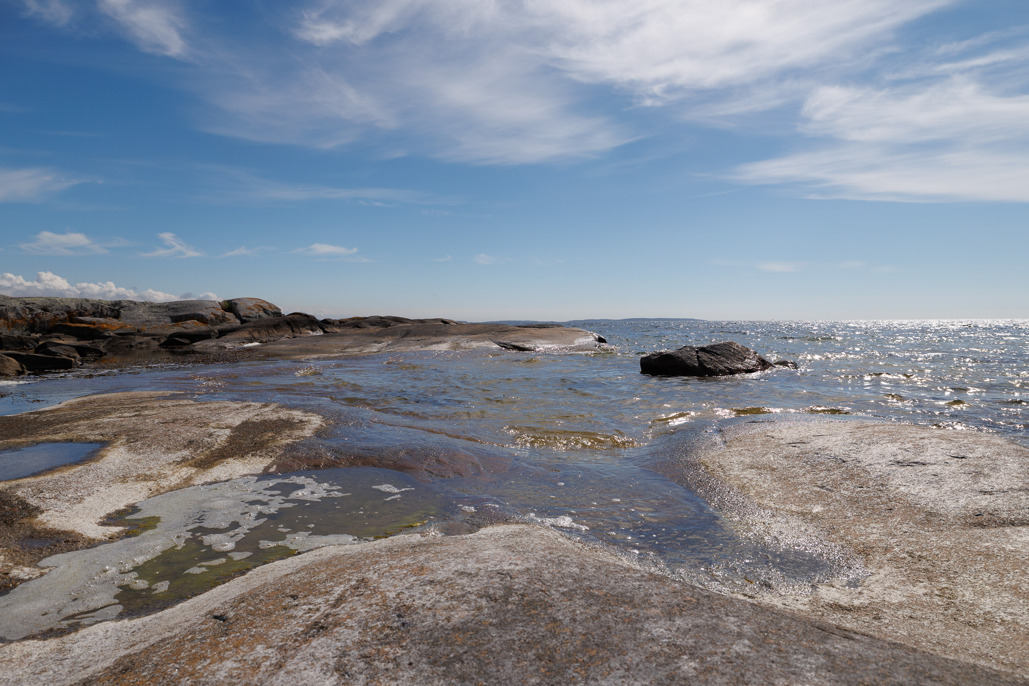Havsvågor mot släta klippor i vårsol i Stärnö-Boön Naturreservat